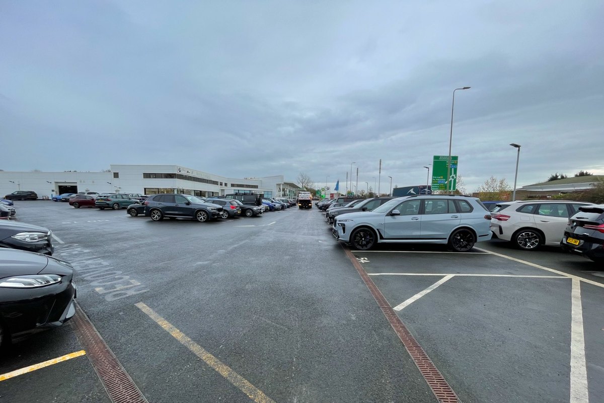 Car dealership commercial parking lot with vehicle inventory rows